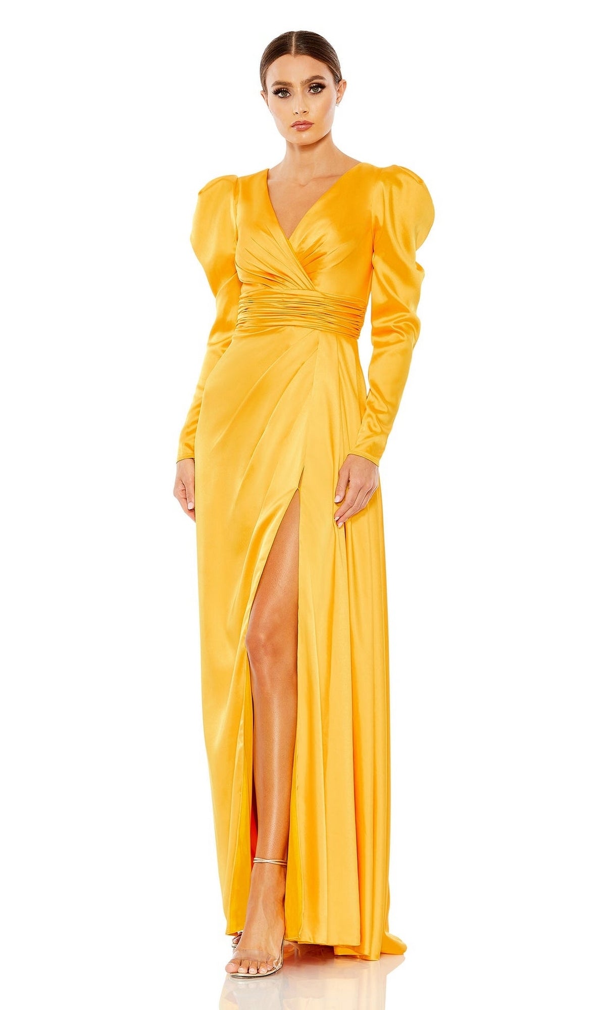 Woman wearing the Long Formal Dress 12404 by Mac Duggal, featuring bright yellow satin, a V-neck, puffed shoulders, wrapped bodice, long sleeves, high side slit, and strappy heels.